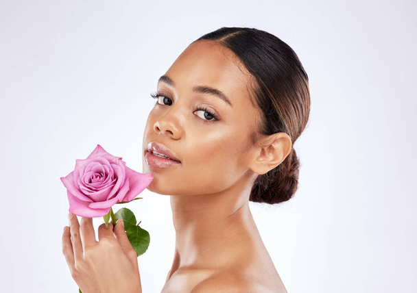 Nature creates miracles and so will you. a young woman posing holding a rose against a studio background - Foto, Imagen
