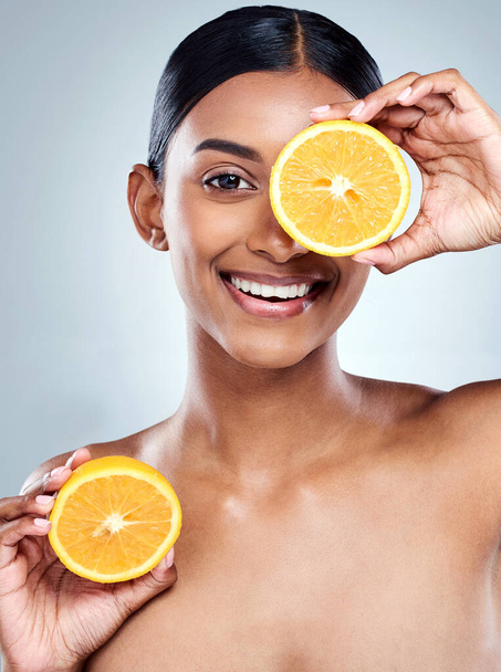 Vitamin C does the body good. Cropped portrait of an attractive young woman posing in studio against a grey background - Fotografie, Obrázek