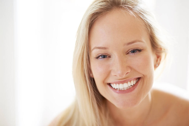 Her smile can brighten any room. Closeup of a beautiful young woman looking at you with a happy smile - Foto, Bild
