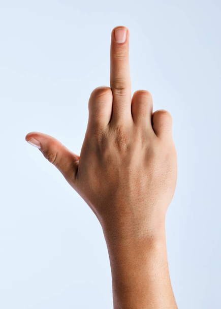 Sometimes you just have to give them the finger. an unrecognizable man holding out his hand showing the middle finger against a white background - Photo, Image