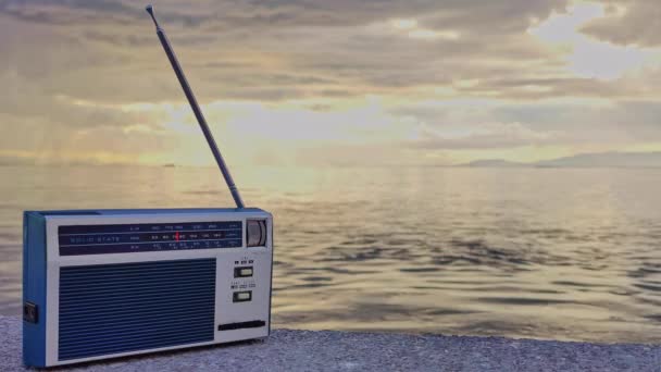 Παλιού στυλ Vintage εγχειρίδιο ραδιόφωνο τσέπης σε μια συννεφιασμένη μέρα στην παραλία Πλάνα. - Πλάνα, βίντεο