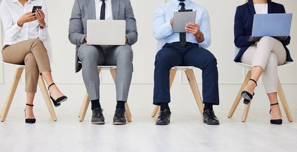 Unknown group of diverse businesspeople waiting for interview and using technology. Team of applicants sitting together. Professional candidates in line for job opening, vacancy and office opportunit. - Foto, Imagem