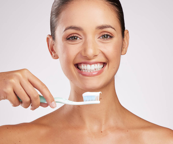 Un bel sorriso ne vale la pena. una giovane donna attraente che si lava i denti su uno sfondo da studio - Foto, immagini