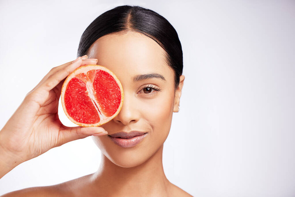 Natuurlijke huidverzorging werkt het beste voor mij. Studio portret van een mooie jonge vrouw poseren met een grapefruit tegen een witte achtergrond - Foto, afbeelding