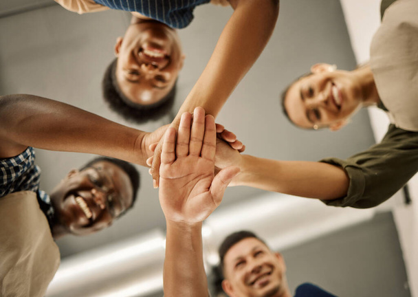 Diverse businesspeople hands stacked from below. Group of fashion designers celebrating and motivating each other. Tailors huddled with hands piled. Group of designers having fun with hands stacked. - Photo, Image