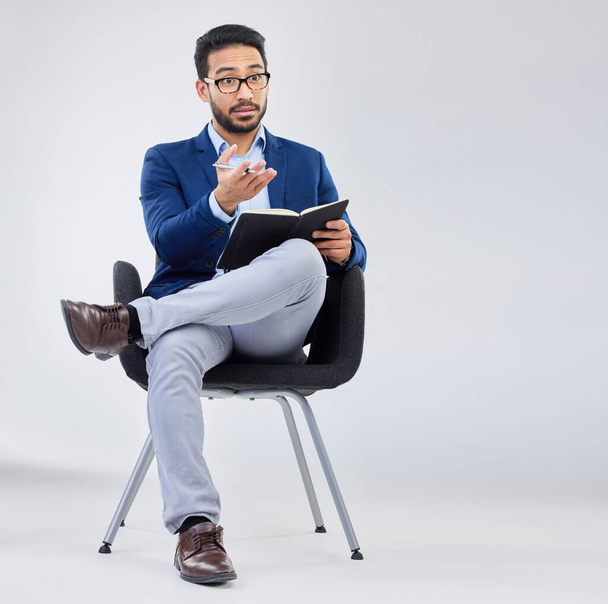 Questions, human resources and businessman with notebook for interview process in studio on grey background. Recruiter, asian male and recruitment process, negotiation and onboarding discussion. - Photo, Image