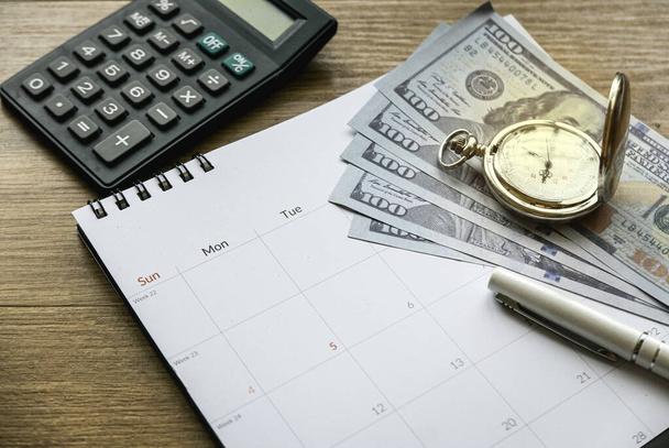 Vero aikaa ja säästää rahaa ja taloudellista suunnittelua käsite. Lasketaan kuukausikuluja. Velanperinnän määräaika. Raha, kalenteri, kello ja laskin puupöydällä. - Valokuva, kuva