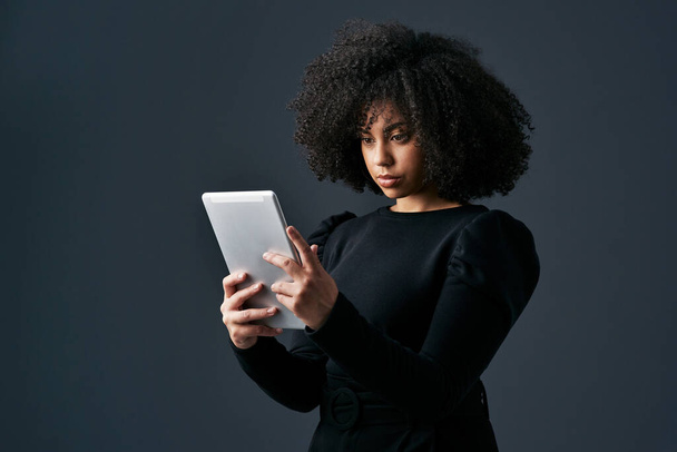 I just got an exciting business deal. a young businesswoman using a digital tablet against a studio background - Φωτογραφία, εικόνα