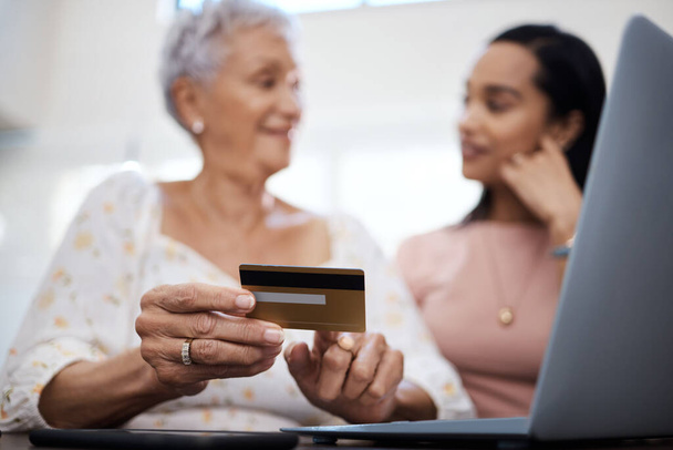 Damals bezahlten wir Rechnungen bei der Bank. eine Seniorin mit Laptop und Kreditkarte bei ihrer Tochter zu Hause - Foto, Bild