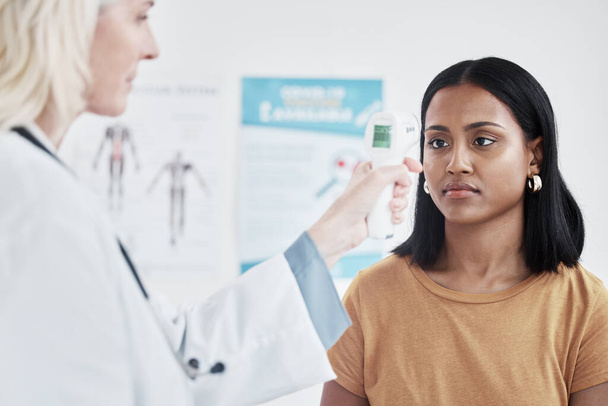 Если у вас лихорадка, это, вероятно, инфекция. врач осматривает женщину с термометром - Фото, изображение