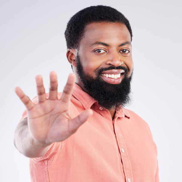 Black man, hand and stop in studio portrait with smile, sign language and communication by background. Young african model, signal or symbol for opinion, protest palm and voice with confident pride. - Photo, Image