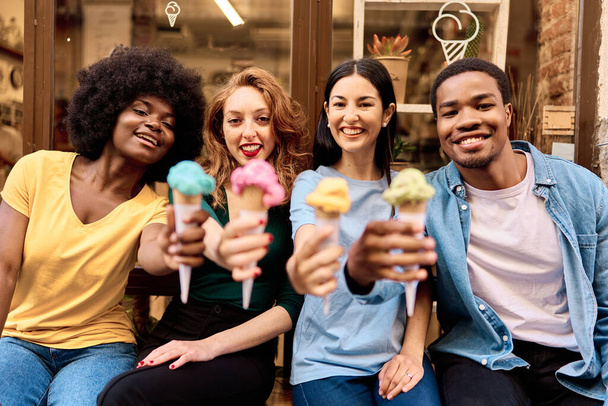 Retrato frontal con enfoque en la cara feliz de las personas multiétnicas con un helado - Foto, Imagen