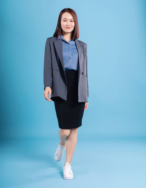 Asian businesswoman on blue background - Foto, afbeelding