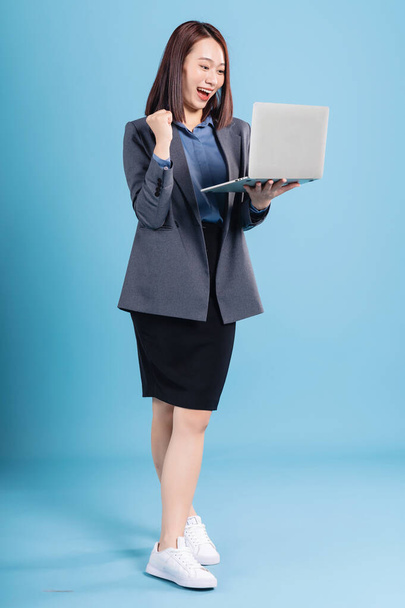 Asian businesswoman on blue background - 写真・画像