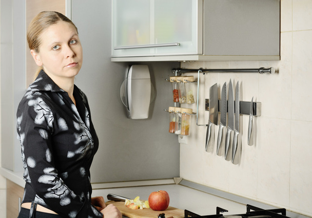 Женщина порезала яблоко на кухне
 - Фото, изображение