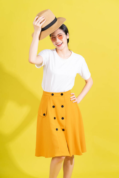 Portrait of young Asian girl on yellow background - Valokuva, kuva