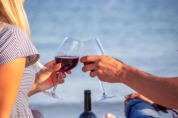 Романтическая пара наслаждается вином у моря. Селективный фокус - Фото, изображение