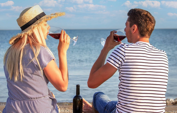 Ρομαντικό ζευγάρι που απολαμβάνει κρασί δίπλα στη θάλασσα. Επιλεκτική εστίαση - Φωτογραφία, εικόνα
