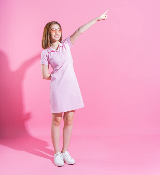 Full length photo of young Asian girl on pink background - Foto, afbeelding