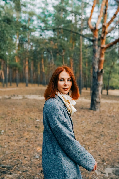 Happy beautiful woman with red hair walking in autumn forest. - Foto, immagini