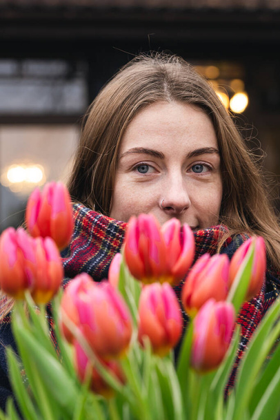 Close-up, bouquet of pink tulips in female hands, urban portrait, spring walk. - Photo, Image