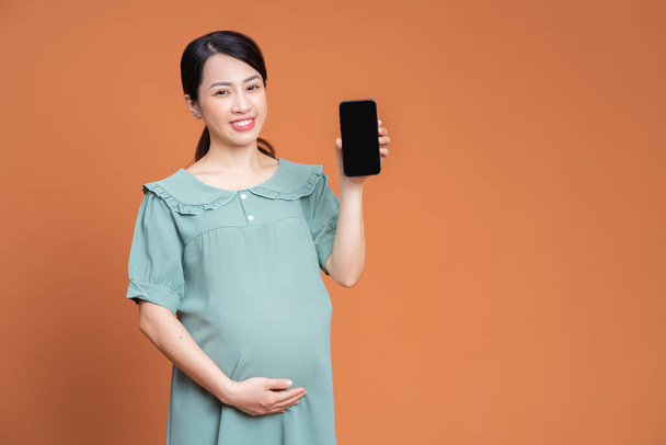 Foto der asiatischen schwangeren Frau auf dem Hintergrund - Foto, Bild