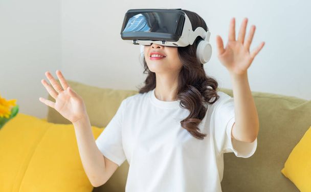fiatal ázsiai nő használ virtuális valóság szemüveg otthon - Fotó, kép