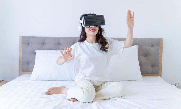 jonge aziatische vrouw met behulp van virtual reality bril thuis - Foto, afbeelding