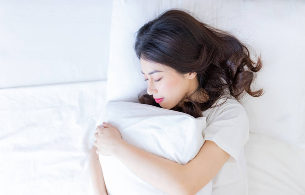 joven asiático mujer durmiendo en cama - Foto, imagen