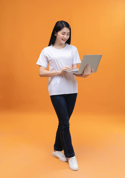 Young Asian girl using laptop on back ground - Fotografie, Obrázek