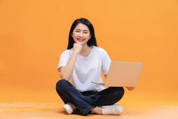 Young Asian girl using laptop on back ground - Zdjęcie, obraz