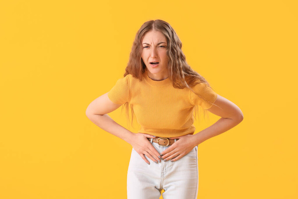 Молодая женщина с аппендицитом на желтом фоне - Фото, изображение