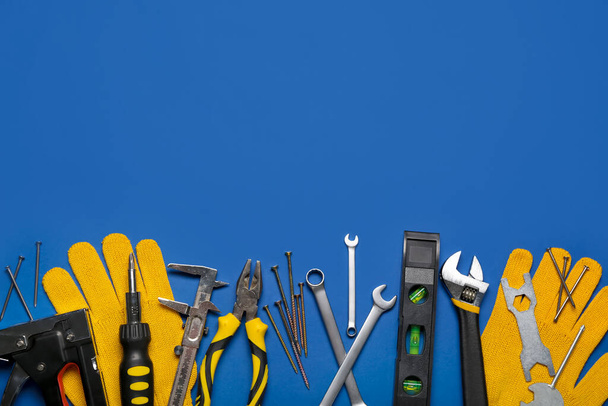 Διαφορετικά εργαλεία και γάντια σε μπλε φόντο - Φωτογραφία, εικόνα