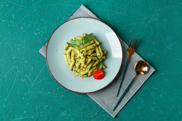 Plate with pesto pasta on green background - Photo, image
