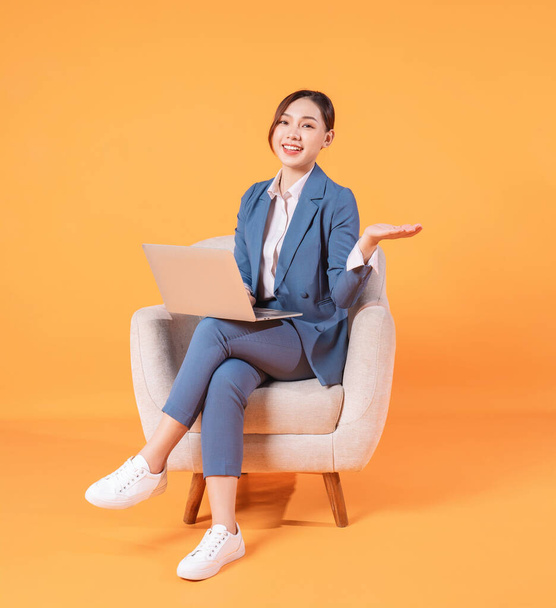 Photo of young Asian businesswoman sitting on armchair - Фото, зображення