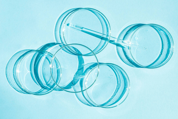 Placa de Petri. Un juego de tazas Petri. Una pipeta, un tubo de vidrio. Sobre un fondo azul. - Foto, Imagen