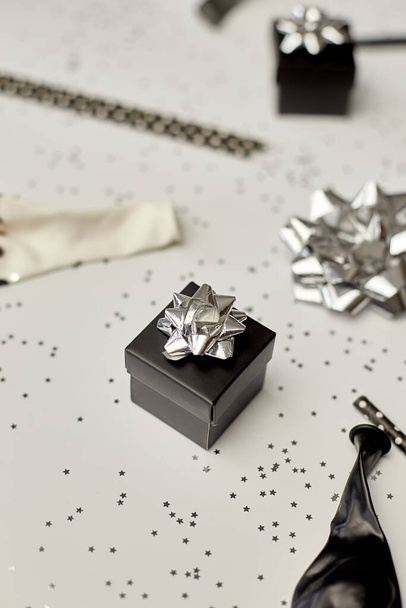Фестиваль день народження вечірка фон з чорно-срібною подарунковою коробкою різні вечірки, повітряні кулі, прикраси на білому тлі, концепція вечірки з днем народження
 - Фото, зображення