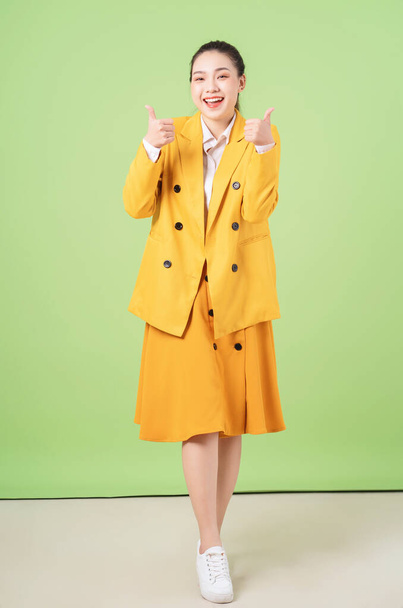 Image of young Asian businesswoman on green background - Fotó, kép