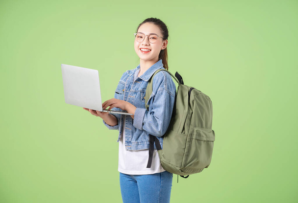Photo of young Asian college girl on green background - Fotó, kép