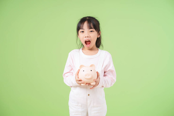 Porträt eines asiatischen Kindes auf grünem Hintergrund - Foto, Bild