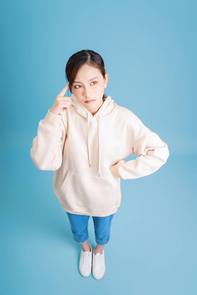 Photo of young Asian girl posing on blue background - Photo, Image