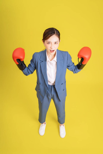 Obraz młodej azjatyckiej bizneswoman z rękawicą bokserską - Zdjęcie, obraz