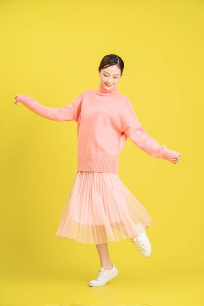 Photo of young Asian girl on yellow background - Foto, immagini