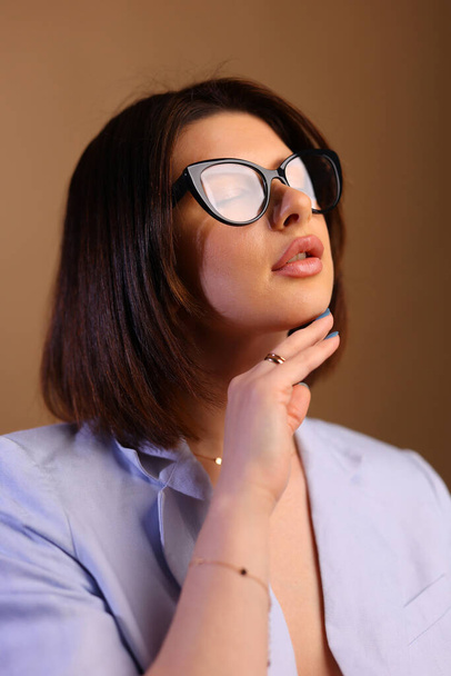 Retrato de belleza de una joven mujer negra sana sosteniendo gafas y mirando a la cámara. Foto de alta calidad - Foto, imagen