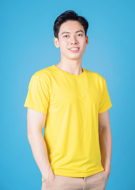 Kuva nuoresta aasialaisesta miehestä, jolla on keltainen t-paita taustalla - Valokuva, kuva