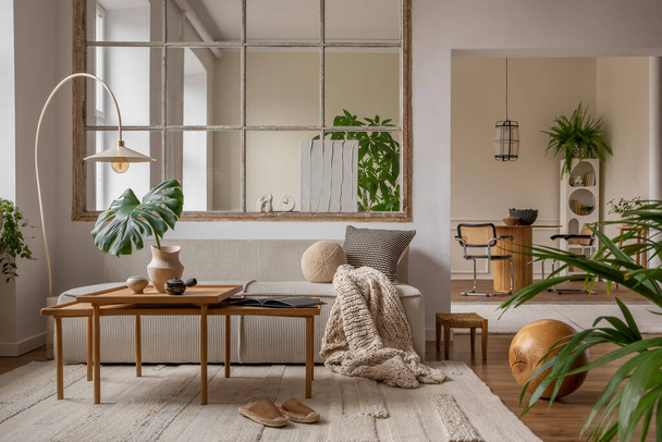 Open space interior with modular sofa, wooden coffee table, big window, beige rug, braided plaid, pillows, round table, lamp, plants, slippers, ball and personal accessories. Home decor. Template. - Φωτογραφία, εικόνα