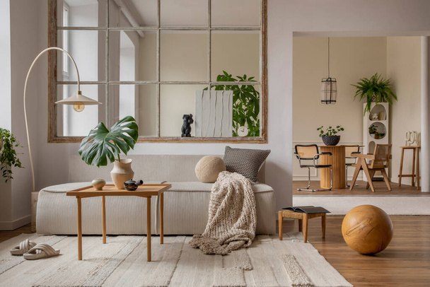 Interior design of open space interior with modular sofa, big window, stylish lamp, wooden coffee table, round table, rattan chair, pillows, plants and personal accessories. Home decor. Template. - Φωτογραφία, εικόνα