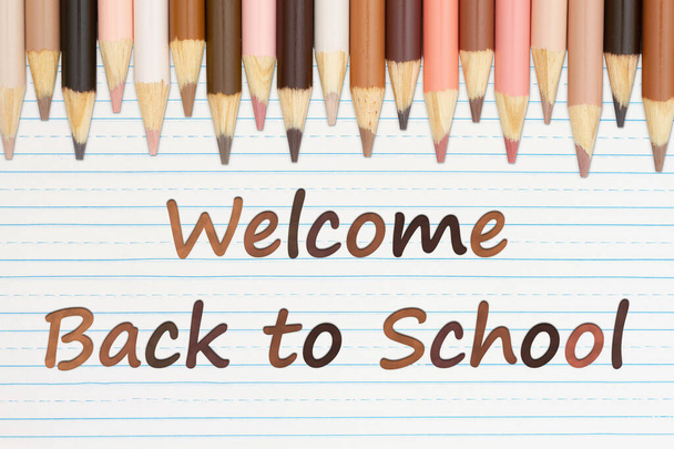 Welcome Back to School message with multiculture skin tone color pencils on lined paper - Foto, Imagem