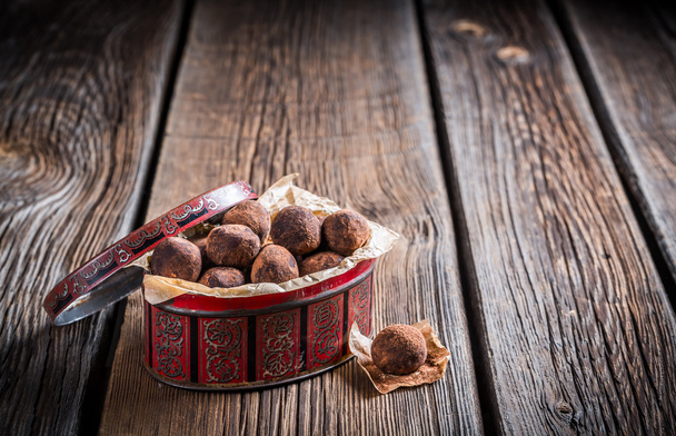 Scatola rossa piena di palline dolci al cioccolato
 - Foto, immagini