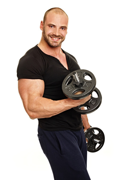 Muscular Man exercises with dumbbells - Foto, afbeelding